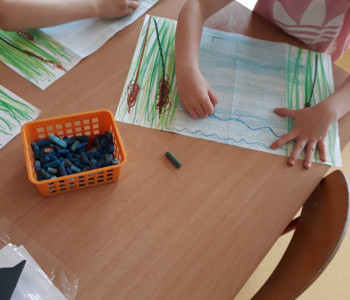 2 dzieci rysuje wodę z trawą