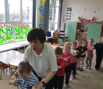 nauczycielka i dzieci tworzą pociąg trzymając się za ramiona 3